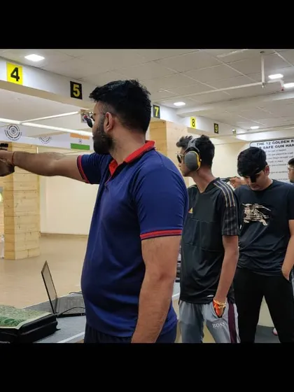 Shooters line up at the 10m range, demonstrating focus and proper shooting stance. You can see the "12 Golden Rules for Safe Gun Handling" posted on the wall, a priority in our academy.