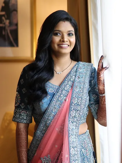 A full view of the bride's reception lehenga and makeup. The bold eyes are balanced with a neutral lip, creating a harmonious and elegant look.