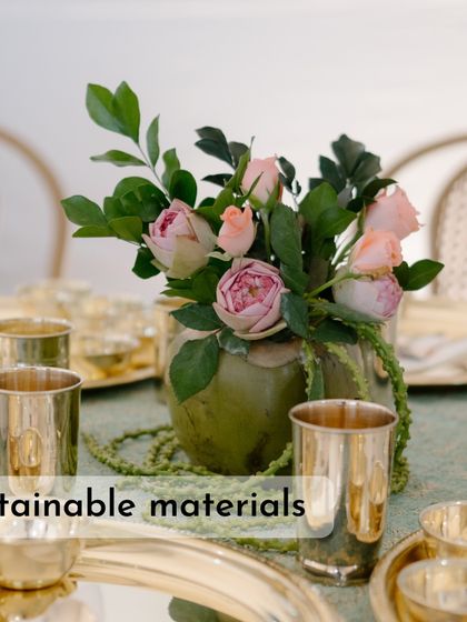 This tablescape uses a coconut shell as a vase, showcasing the trend of using sustainable and natural materials in floral design.