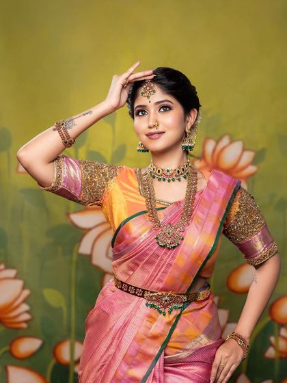 This pose beautifully showcases the intricate details of the blouse embroidery and the traditional jewellery, all complemented by a flawless makeup look.