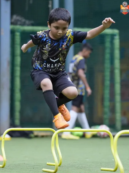 Leaping over hurdles, a young player works on his agility and coordination. These foundational exercises are crucial for developing athletic ability and preventing injuries.