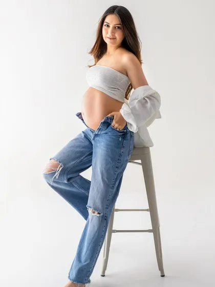 A confident solo portrait that's both casual and glamorous. This shows how a simple outfit can be styled to create a stunning and modern maternity photo.