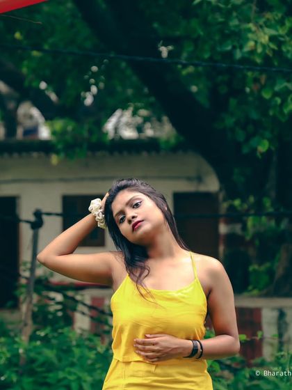 A portrait taken in an urban park, combining natural elements with hints of the city in the background.