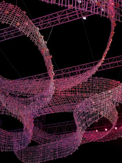 A detail shot of the custom-designed, ribbon-like ceiling installation, showing the intricate weaving and embedded floral elements. This piece was the centerpiece of the reception decor.