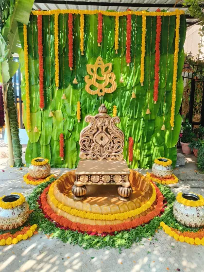 For this outdoor Haldi ceremony, I created an authentic and traditional atmosphere using a backdrop of fresh banana leaves and marigold flower garlands. The setup is centered around an ornate wooden chowki, complemented by decorated earthen pots, perfect for traditional pre-wedding rituals.
