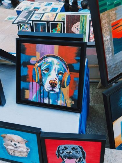 A colorful painting of a dog with headphones, one of the many fun and contemporary pieces available at our 'Sublime Fiesta' art fair.