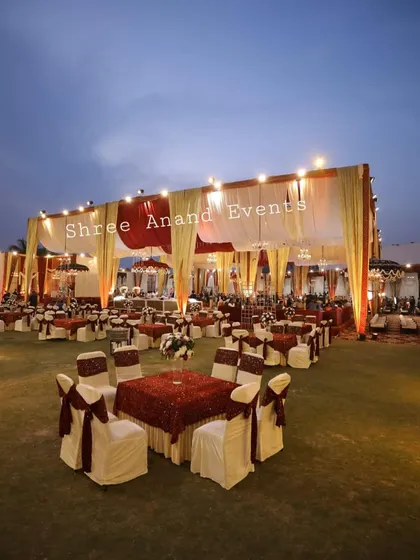 A wide shot of the dining area at dusk, with tables beautifully set under a large, well-lit marquee.