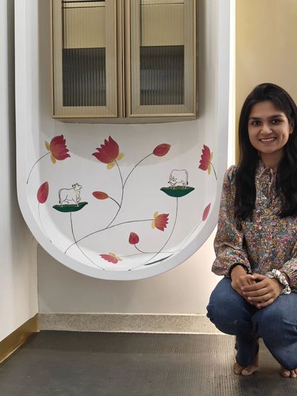 Posing with my completed Pichwai mural in the office. The minimalist style was chosen to align with the classy, modern design of the workspace.