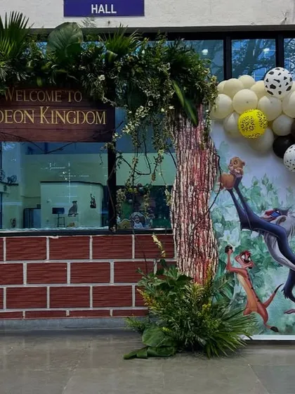 An immersive entrance for a Lion King themed party, styled as the "Gideon Kingdom." We combined a rustic foliage arch with a balloon cascade and character poster to build excitement.