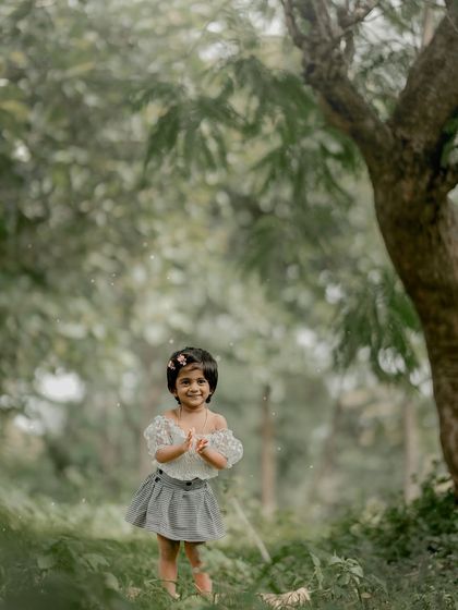 Clapping her hands with glee, this little one is having a wonderful time during her outdoor photoshoot.