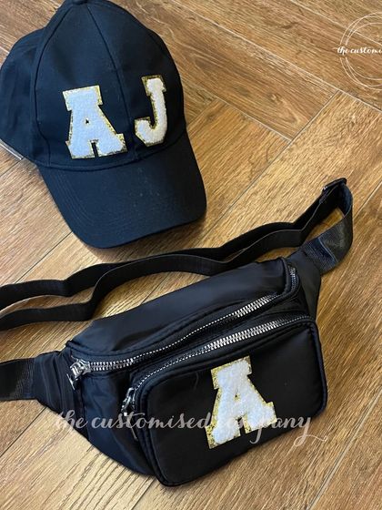 Finding the perfect gift for men is easy with this stylish set. It includes a black fanny pack and a matching baseball cap, both personalized with sparkling initial patches.