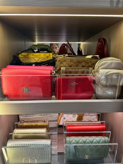 A close-up view of how clear acrylic dividers can separate and display clutches and wallets within a shelf, maximizing visibility and order.