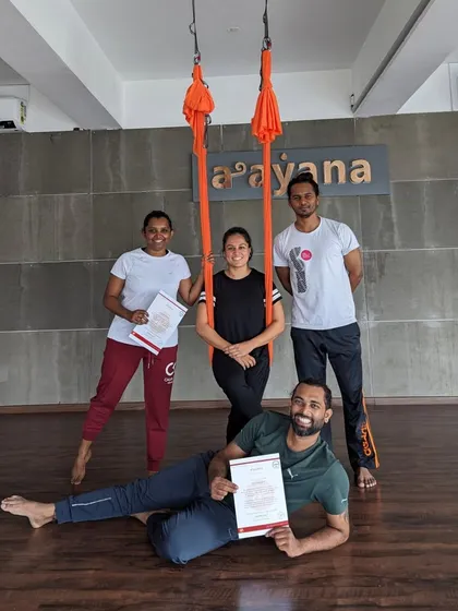 The happy graduates of another successful aerial yoga teacher training course, celebrating together.