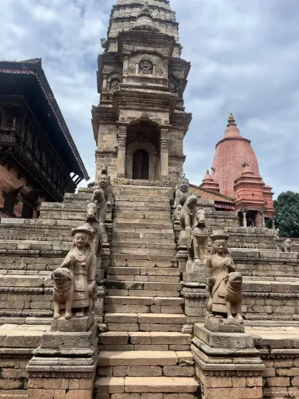 The steps of a temple in Bhaktapur, guarded by mythical stone creatures. This ancient city is a UNESCO World Heritage Site, filled with spiritual and historical treasures.