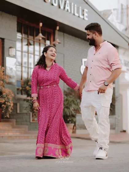 The couple walking hand-in-hand past a quaint storefront, their laughter making for a perfect candid shot.