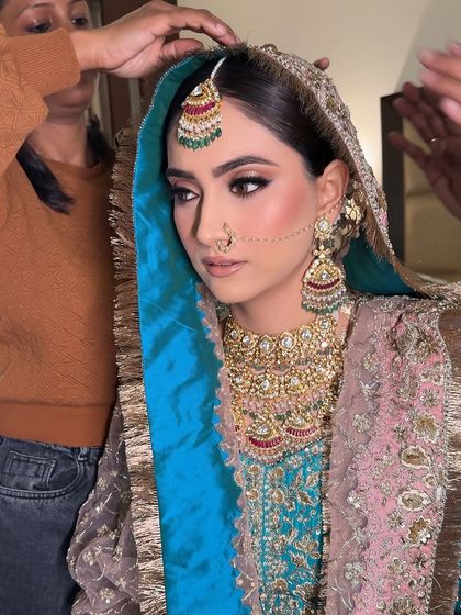 A behind-the-scenes moment of the dupatta setting. Every detail is carefully managed to ensure the bride looks perfect from every angle.