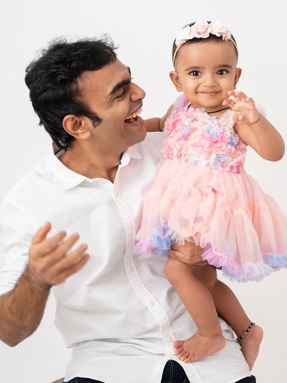 A father holding his daughter up, both of them laughing. The dynamic energy in this photo perfectly captures the joy of their relationship.