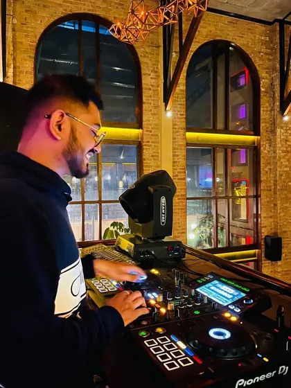 A candid shot of me enjoying the moment while mixing at a beautiful venue with large arched windows. Good music, good friends, and good vibes are what it's all about.