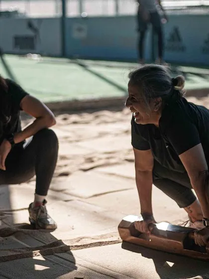 Two women share a laugh while training with Samtolas in the sandpit. This image perfectly captures the community and fun aspect of our workouts, where hard work and enjoyment go hand in hand.