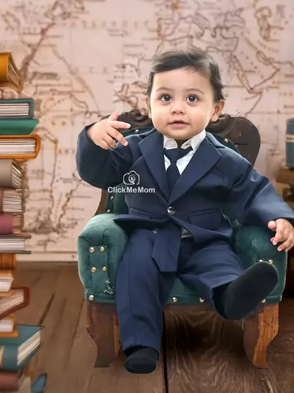 This little boss is ready to take on the world. The classic suit and stack of books create a powerful and adorable portrait.