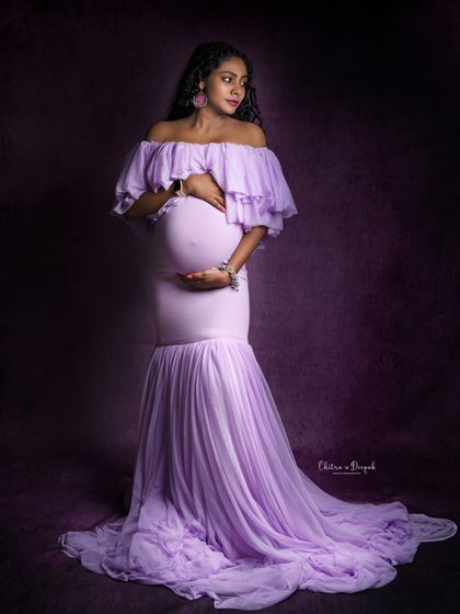 A stunning profile in lavender. This off-shoulder mermaid gown beautifully accentuates the baby bump for an elegant and timeless look.
