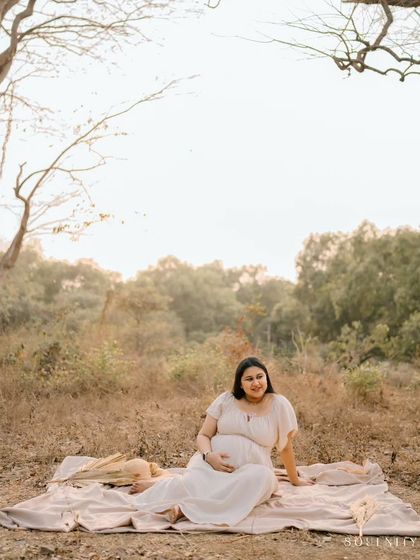 Surrounded by the quiet beauty of nature, this mama-to-be takes a moment to connect with the little life she is nurturing.