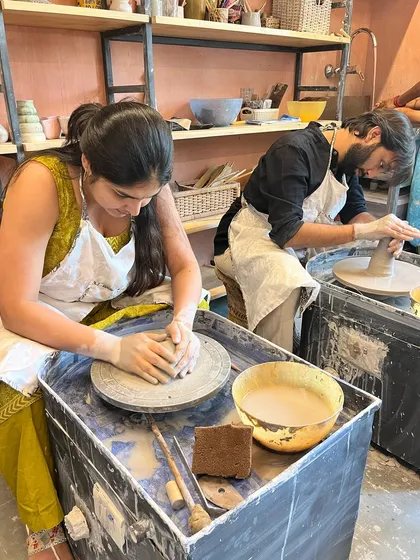 A couple enjoys a focused, creative session side-by-side on the pottery wheels.