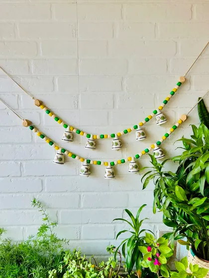Our 'Khanak' beaded bell buntings in a yellow and green combination. The vibrant wooden beads and mini ceramic bells create a harmonious blend of color and sound, perfect for any cozy corner.