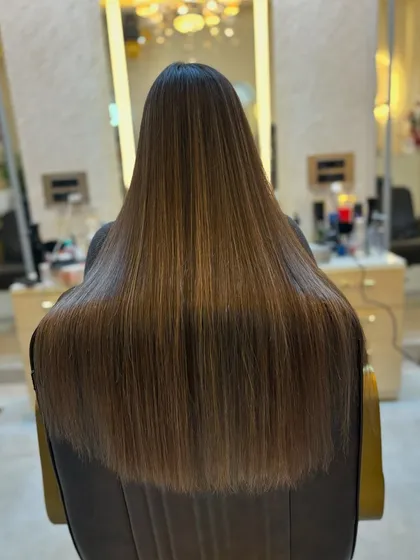 The light reflecting off this long, straight caramel brown hair highlights its incredible health and shine.