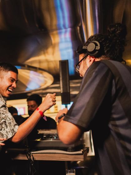Sharing a laugh while spinning records at a pre-party for the Jazz Weekender. Vinyl sets create a relaxed, conversational atmosphere perfect for intimate events.