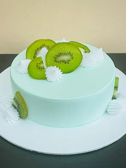A refreshing Kiwi Cake, with its light green frosting and decoration of fresh kiwi slices. It's a wonderfully tangy and light dessert option.