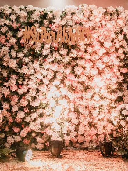 A beautiful floral photo wall made of blush and white carnations. The custom wedding hashtag adds a personal touch, creating the perfect backdrop for guest photos.