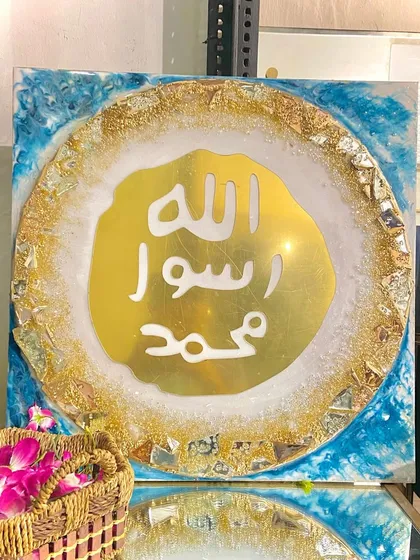 This luxury wall art features the Mohr e Nabuwat, or the Seal of Prophet Muhammad (PBUH). The design is set in gold and turquoise resin with a geode-like textured border, perfect for an exquisite living room.