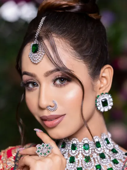 A new-age bridal look with soft smokey eyes, nude lips, and beautiful emerald and diamond jewelry.