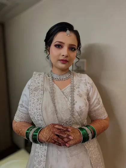 The full look, showing the white embroidered lehenga paired with traditional green bangles, a beautiful fusion of modern and traditional styles.
