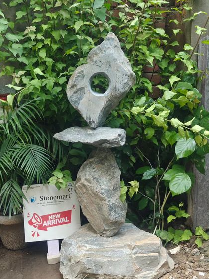 The 'Balance of Life' sculpture stands complete against a lush green backdrop. Its form is both modern and timeless, making it a perfect addition to a high-end garden or resort landscape.