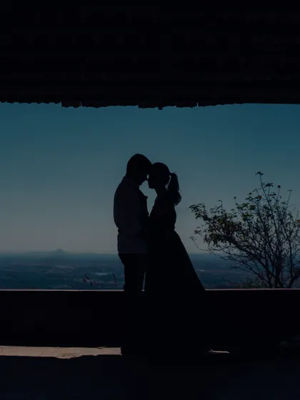 This silhouette shot, framed by a pavilion, creates a private, intimate world for the couple against a vast and beautiful landscape.