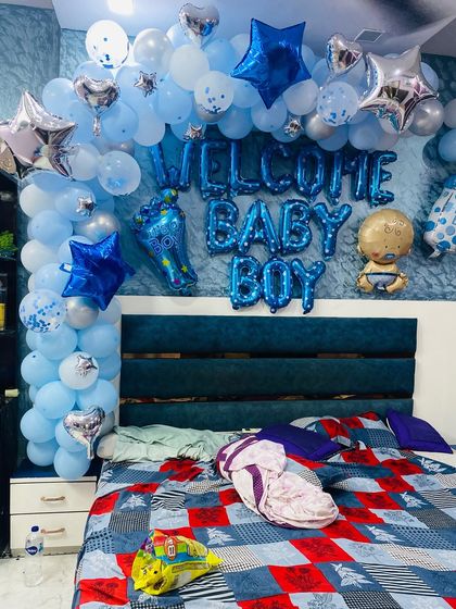 Another angle of the 'Welcome Baby Boy' bedroom decoration, showing the full balloon arch over the bed.