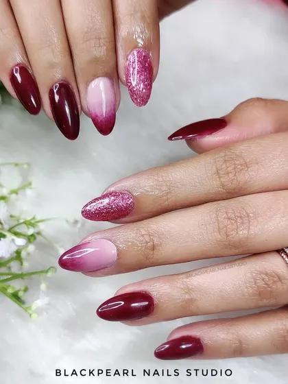 A stunning set of wine-colored nails with an ombré effect and a touch of glitter. The deep wine fades into a softer shade, creating a dramatic and elegant look perfect for any season.