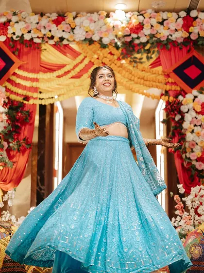 A joyful twirl in a stunning sky blue lehenga. The dewy makeup look is perfect for a fun-filled Sangeet night.