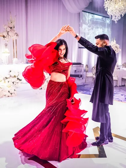 From the wedding ceremony to the reception, your style should tell a continuous story. For Munpreet and Manish's reception in Australia, we went for a classic red and black theme. She is a vision in a dramatic Gaurav Gupta ruffled gown, ready to dance the night away.