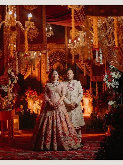 A stunning shot of the wedding mandap, rich in red and gold decor. This image captures the traditional grandeur and opulence of the ceremony space.