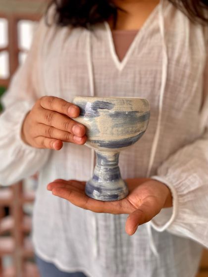 A student holding a beautiful marbled goblet she made. It's a treat to watch students develop their own unique styles.