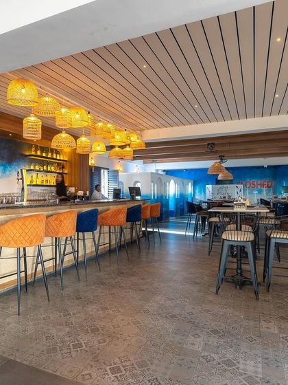 Another view of the transformed bar area, showing the open and airy layout. The design uses color and lighting to define different moods within the same space.