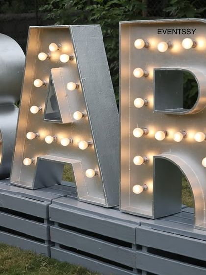 Large, silver marquee letters spelling out "BAR" for an event. This is a great way to designate different areas of a party and add a touch of industrial-chic style.