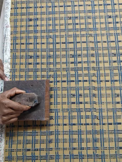 Here, we are printing on corduroy fabric using a natural resin discharge technique. It's always a joy for our artisans to experiment with different materials and see how our traditional methods adapt to new textures.