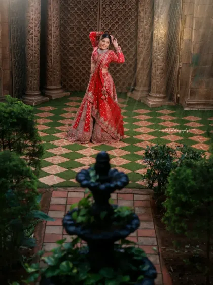 A creative composition using a fountain in the foreground to frame the bride against a grand doorway. This adds depth and a sense of scale to the portrait.