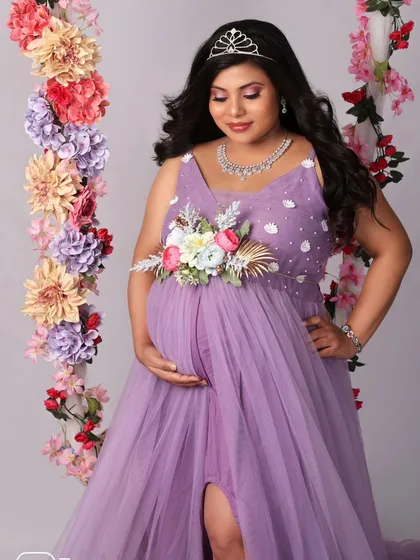 A close-up on the swing, capturing the serene expression and beautiful details of the floral belt and tiara. A portrait fit for a queen.