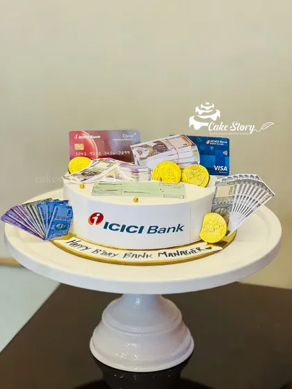 A cake designed for a bank manager's birthday. It's decorated with edible money, credit cards, and the ICICI Bank logo, making it a fun and personalized gift.