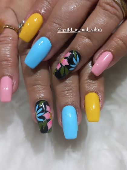 A bright and cheerful multi-color set. Solid yellow, blue, and pink nails are paired with accent nails featuring hand-painted tropical flowers on a black base.